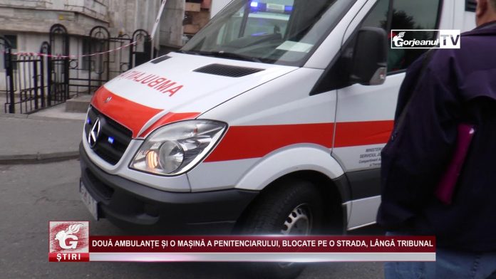 DOUĂ AMBULANȚE ȘI O MAȘINĂ A PENITENCIARULUI, BLOCATE PE O STRADA, LÂNGĂ TRIBUNAL