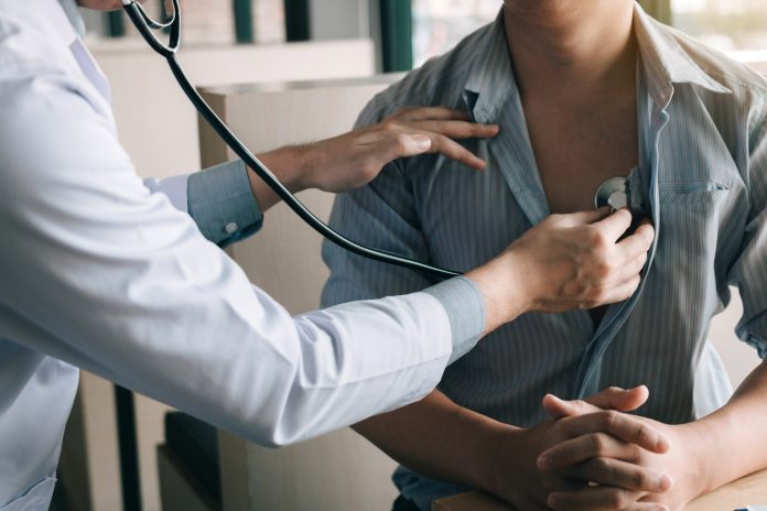 Midsection Of Doctor Examining Patient With Stethoscope In Hospital