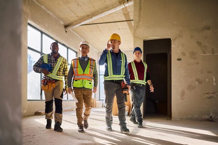 Senior,Architect,And,Group,Of,Construction,Workers,Walking,Through,Building