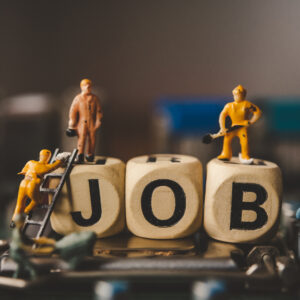 Miniature people or small figure worker on wood block with the w